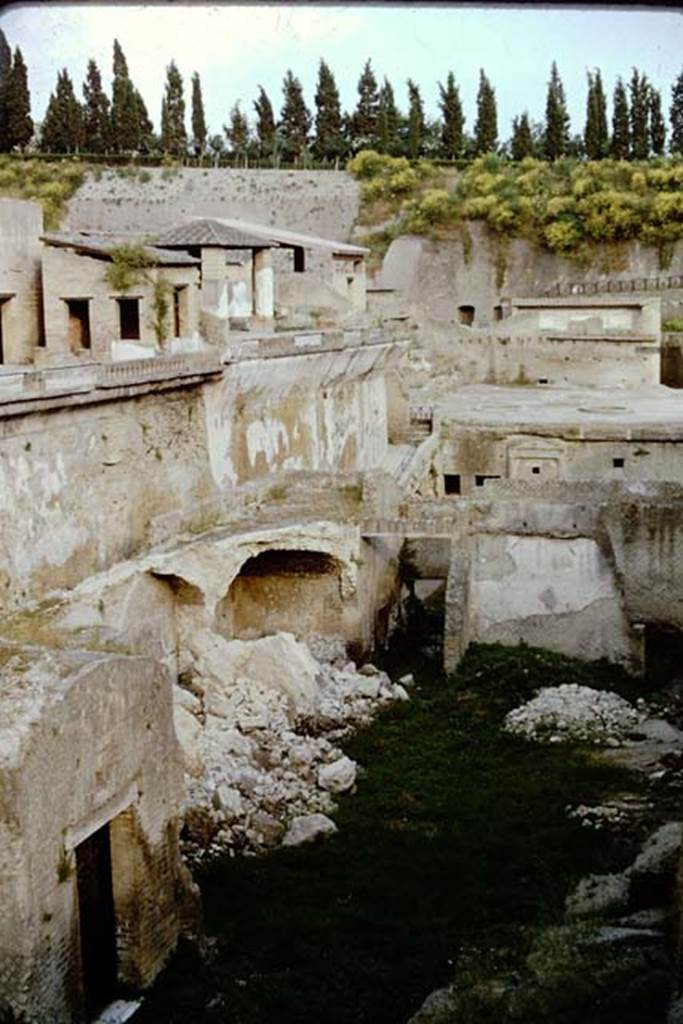 Herculaneum, 1961. Looking east from the shrine of Venus, across the Sacred Area, with the terraces of the House of Mosaic Atrium, and House of the Stags, above it.
Photo by Stanley A. Jashemski.
Source: The Wilhelmina and Stanley A. Jashemski archive in the University of Maryland Library, Special Collections (See collection page) and made available under the Creative Commons Attribution-Non Commercial License v.4. See Licence and use details. J61f0601